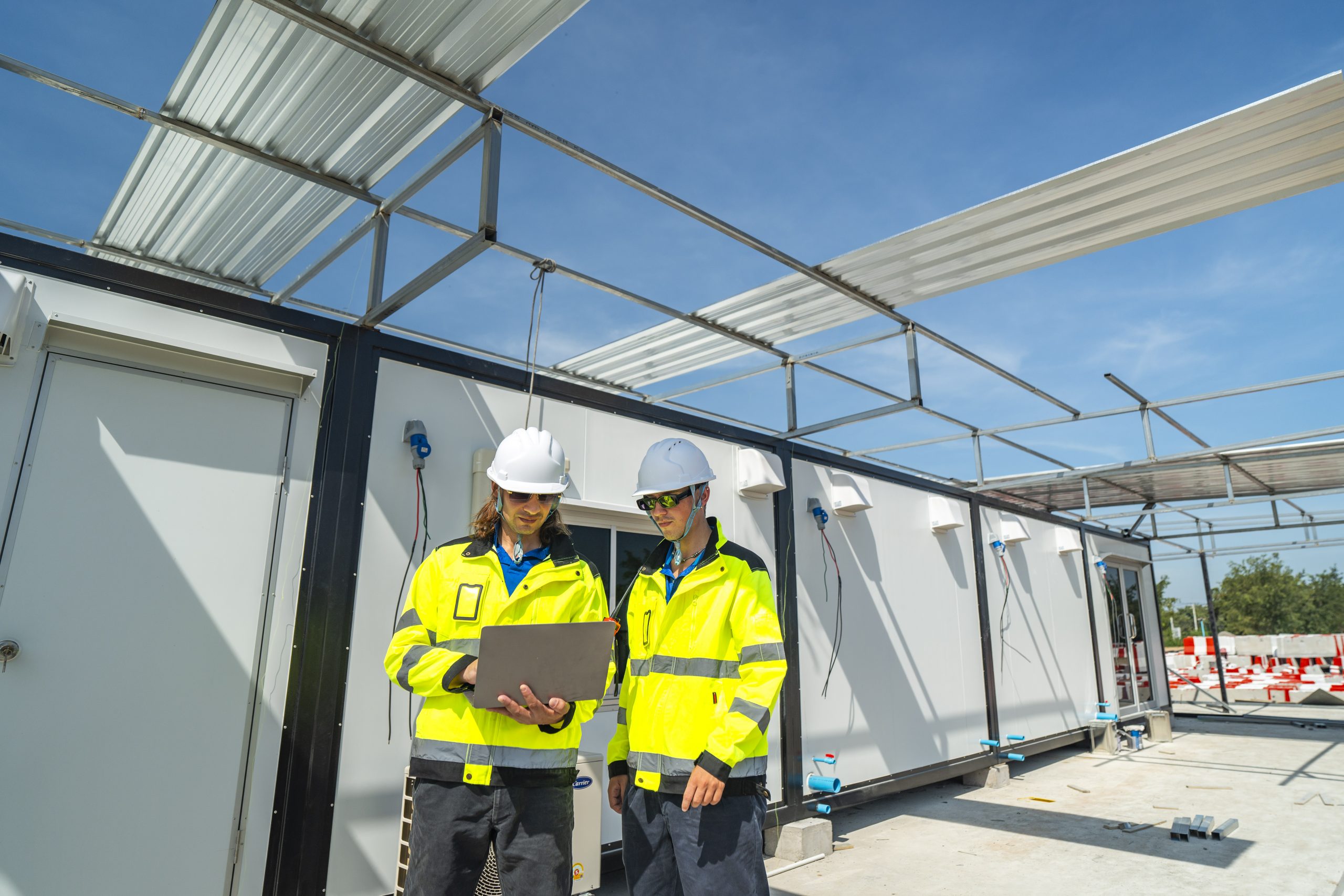 Ein Ingenieur mit Sichtschutzjacke und Helm arbeitet auf der Baustelle.