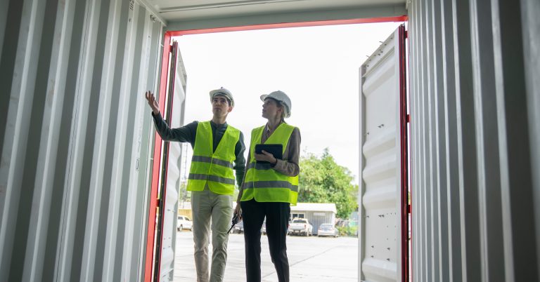 Foreman diskutiert für Stapelcontainer beim Transport von Frachtstandort-Logistikdiensten.